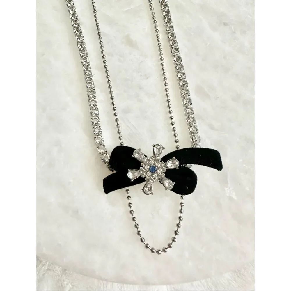 Christmas snowflake tennis necklace with black bow and light blue detail ￼